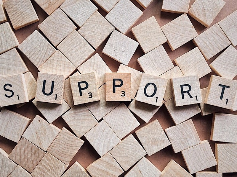 Abbildung von Scrabble Steinen mit den Buchstaben, die zusammen das Wort "Support" ergeben